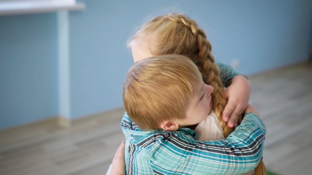 Devojčica i dečak se grle, pokazujući empatiju i emocionalnu bliskost